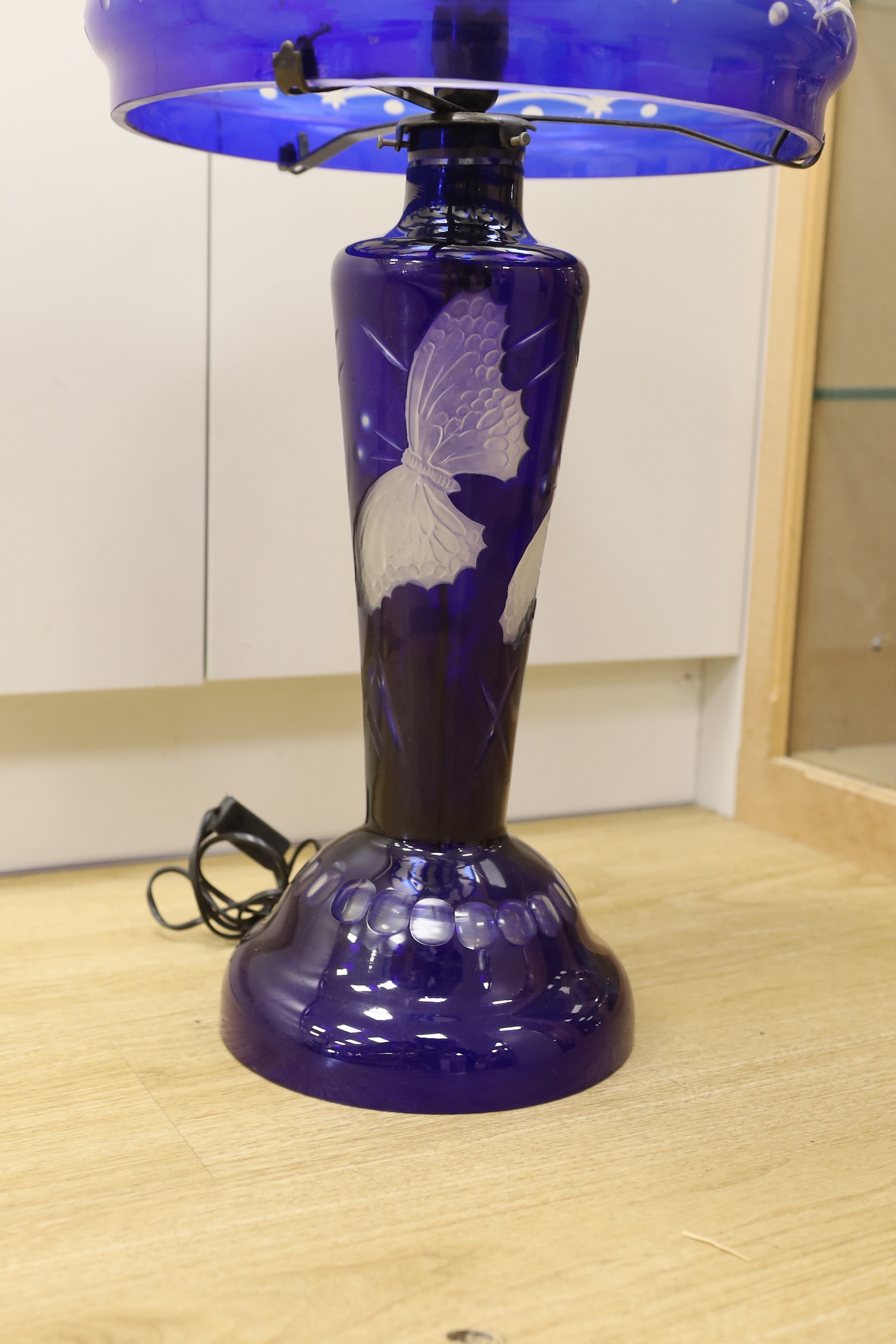 A blue flashed glass mushroom shaped table lamp, with butterfly engraving, 70cm high